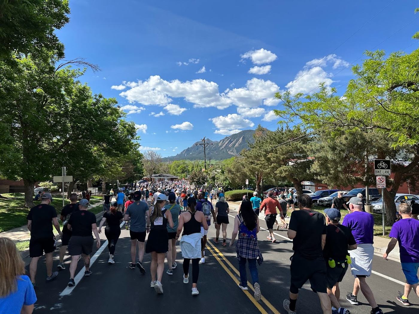 Runners on the BolderBoulder 10K course with the Flatirons behind them